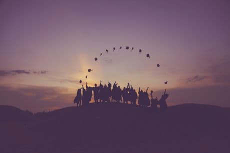 graduates throwing caps in the air