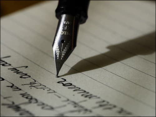 student writing a listen with a fountain pen