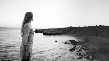 woman looking at the shoreline of the sea