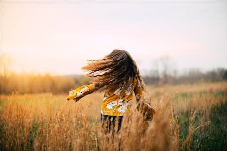 little girl running through a field dreaming about her life