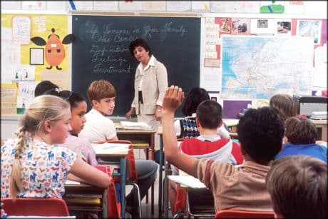 picture of a teacher asking a question to a group of young students