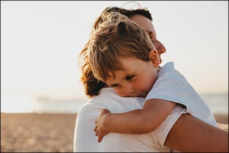 woman holding a little boy, showing kindness