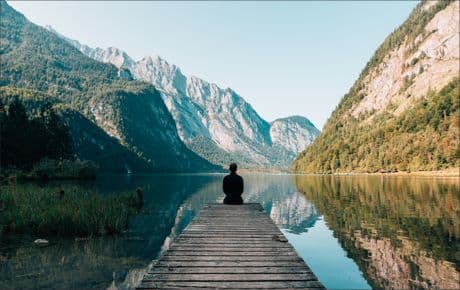 man on a dock looks like he's in contemplation or meditation