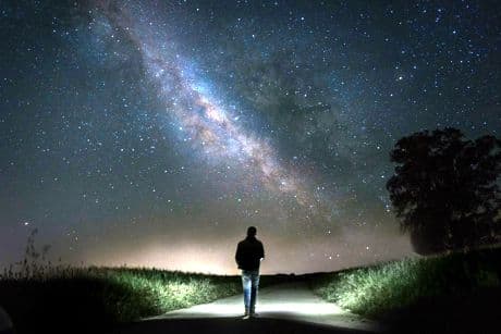 man looking at up at the night sky