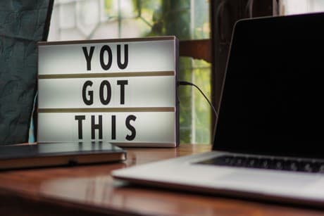 black and silver laptop, sign that says you got this.